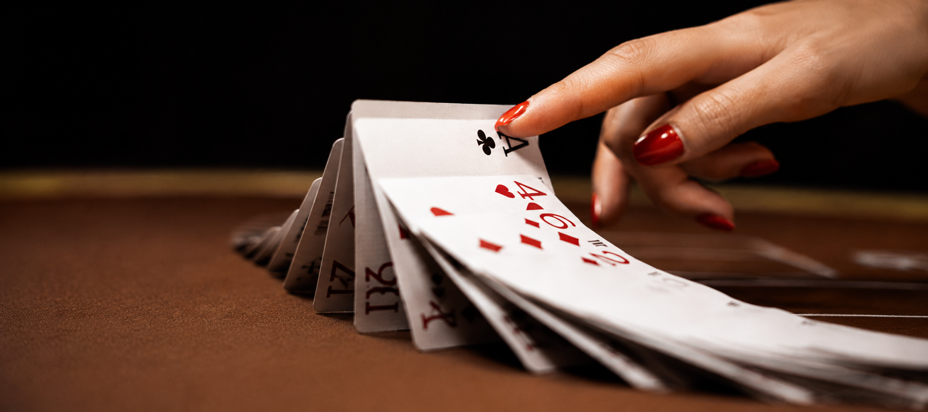 Dealer hand spreading playing cards on a casino table